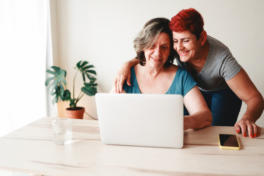 Senior gay lesbian couple using computer laptop at home. Business and family relationship life style