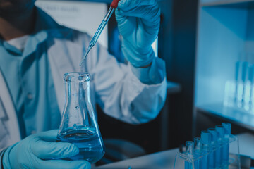 A scientist uses laboratory equipment for a research experiment, test tube is essential for chemists to use in experiments, scientific researchers must concentrate on testing samples in the lab