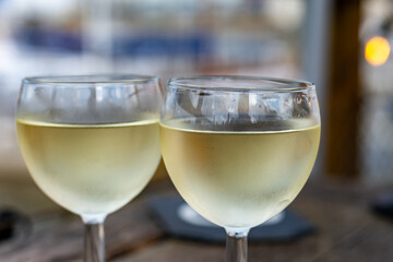 Tasting of Bordeaux white wine, right bank of Gironde Estuary, France. Glasses of white sweet French wine served in outdoor restaurant