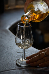 Tasting of cognac spirit aged in old dark French oak barrels in cellar distillery house, Cognac white wine region, Charente, Segonzac, Grand Champagne, France