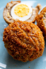 Traditional street food in UK, stuffed fried Scotch eggs with breadcrumbs close up
