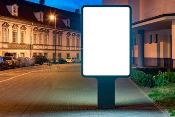 Street Billboard Mockup In The City At Night. Outdoor Advertising Lightbox with a parking lot in the background