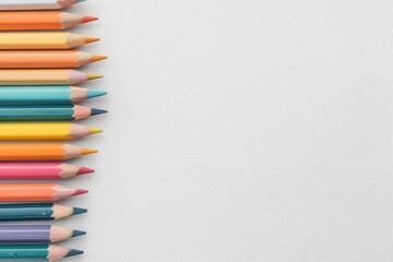 Fototapeta premium Colorful pencils aligned on the left side of a blank white background. Perfect for art, education, or creativity-themed projects.