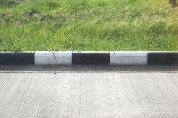black and white curb road cement texture with green grass