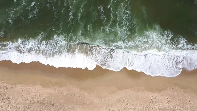 aerial view of waves crashing on the beach