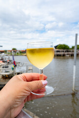 Tasting of Bordeaux white wine, right bank of Gironde Estuary, France. Glasses of white sweet French wine served in outdoor restaurant on oysters farm in Gujan-Mestras, Arcachon bay