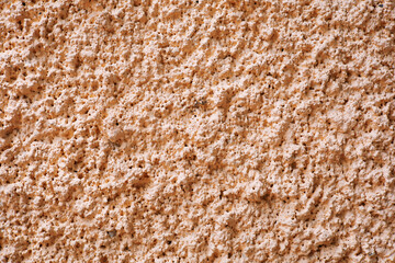 Light orange rough cement surface, close-up photography