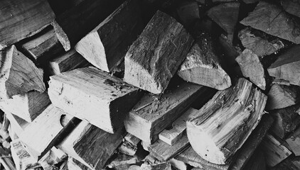 Grayscale Stock Photo Of Old Chopped Wood Logs Sloppily Folded Inside Woodshed
