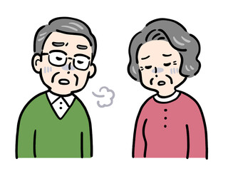 ため息をつき顔色の悪いシニア夫婦