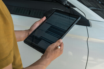 A businessman stands next to his damaged vehicle after an accident, holding a clipboard and examining the scene. An insurance agent arrives to assess the damage and start the claim process.