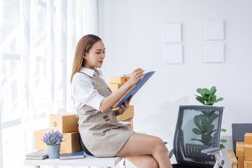 Beautiful Asian online business owner is preparing a parcel box to prepare the package for delivery to the customer asian Entrepreneur SME business concept.