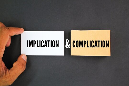 white and brown paper with the words implication and complication