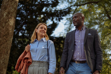 Fototapeta premium Two businesspeople casually walking in the park
