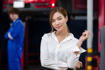 Portrait business woman standing front car at maintenance garage. woman car repair service in automobile garage.