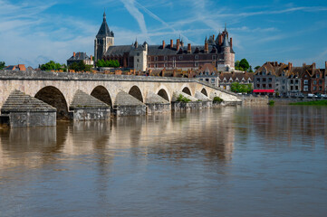 Fototapeta premium View.on old part of town of Gien on the Loire river, in Loiret department, France, houses with tiled roofs and chimneys, castle and bridge