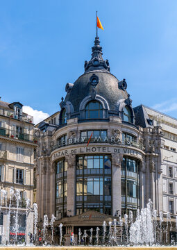 Paris, France - June 03 2024: Facade of the BHV (Bazar de l'Hotel de Ville) with water fountain in the foreground