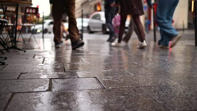 People walking on the street in the rain in Paris, France
