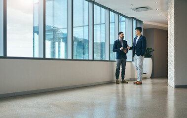 Office, consulting and men in lobby together talking, planning and networking for collaboration. Discussion, partnership and business people at window with advice, team support and project management