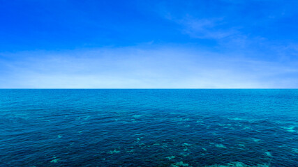 Ocean background and sea water and clear sky. For summer vacation ideas The nature of the beach and summer sea with the sun shining on the sea sparkling against the blue sky.	