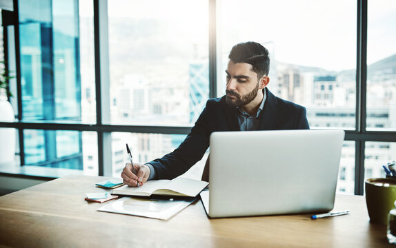 Laptop, notebook and business man writing for financial analysis, company review and data analytics. Corporate office, consultant and person with notes on computer for research, website and planning