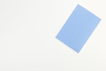 Top view of blue notebook on white background. School, office wallpaper. Flat lay, copy space.