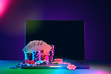 Laptop With Playing Cards and Poker Chips on a Green Table