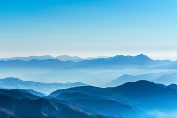 A breathtaking view of a distant mountain range with layered peaks under a clear sky, showcasing natural beauty and serene landscapes