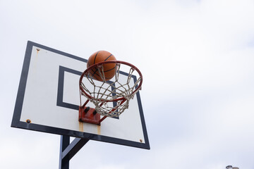 Scoring point, basketball going through hoop during outdoor game © WavebreakMediaMicro