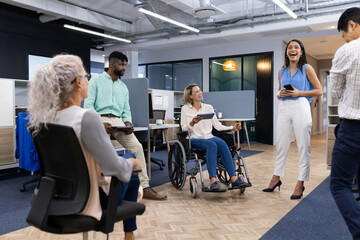 Group of business people in office having meeting, discussing ideas, smiling