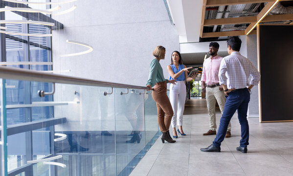Group of business people discussing project in modern office hallway