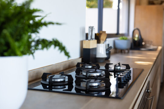Modern kitchen with gas stove and knife set on countertop, bright and clean, copy space