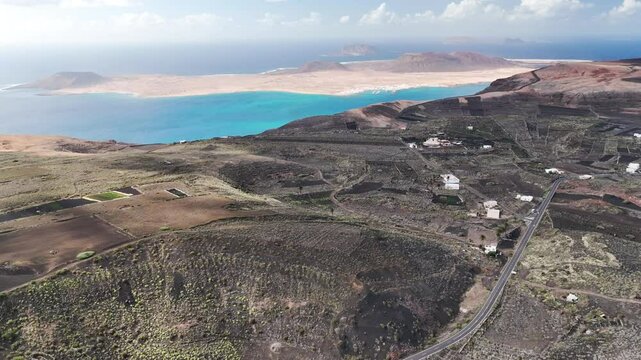 Lanzarote Land View towards La Graciosa Island and in front of the Famara cliffs. Farm Land with special canary island origin farming method builded. Picon floor and stone boarders.