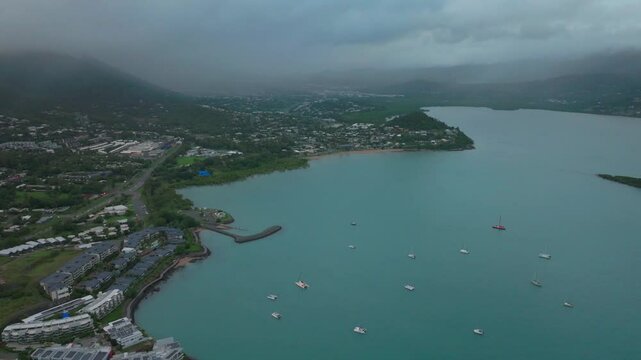 Rainy Port Airlie Beach Bay Lagoon Coral Sea marina aerial drone road cars towards Cannonvale pink yellow sunrise morning heart of Great Barrier Reef Whitsundays Whitehaven boats backwards
