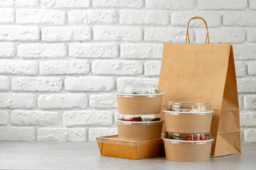Take out food in boxes and craft bag against brick background