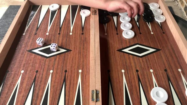 Backgammon Gameplay: Young Woman Makes Splitting Move