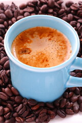 エスプレッソに牛乳をたっぷり入れたコーヒー、カフェ・ラッテと、深煎りしたコーヒー豆
