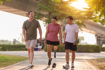 Obraz premium Friend support Friend with a prosthetic leg while exercising outdoor. People walking together on park outdoor. Exercise walking woman with prosthetic leg and friend support together in park outdoor