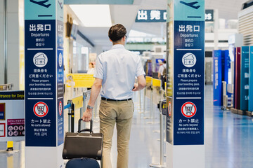 空港内の出発ロビーに向かう男性