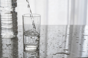 Background image pouring water into the glass cup. Glass cup with water