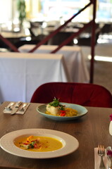 yellow vegetable soup with herbs, squid, pumpkin soup, herbs, plate, serving restaurant table, lunch menu 