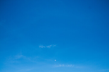 the sky is clear blue and the moon looks small