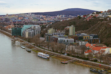 Obraz premium Top view from the observation deck of the Ufo tower on the residential buildings and promenade near danube river with moored boats, Bratislava, Slovakia