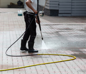 A man washes paving slabs with water