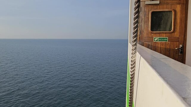Emergency exit door and a thick rope on a ferry sailing during a calm weather