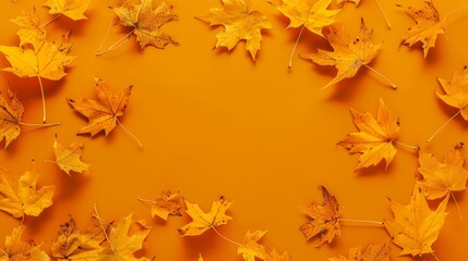 Autumn vibes with scattered yellow maple leaves on orange background