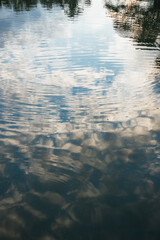 Reflections of a cloudy sky in the calm water