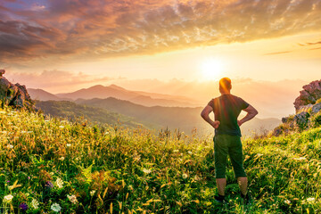 Fototapeta premium happy man watching amazing highland evening sunset, person delight with nature landscape