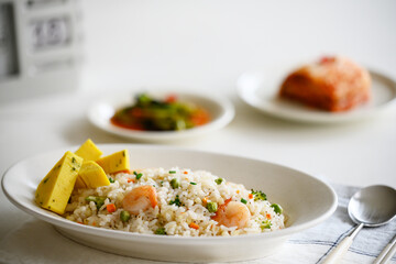 테이블 위에 맛있는 볶음밥과 배추김치, 깍두기 반찬.