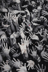 Sculptures of hands reaching out from the darkness