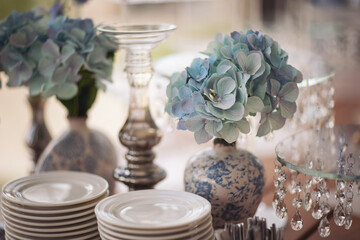 Table with plates stands for candy bar, catering. Decorating an event in restaurant. Wedding hall with atmospheric decor. Golden geometric decorative elements decor. Luxury reception. Setting, setup.